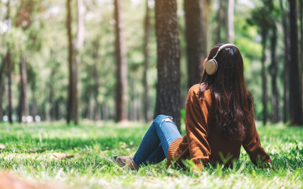 Woman relaxing in the woods with headphones