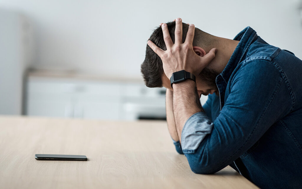 Man stressed with head in hands